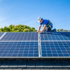 A solar panel installer works on solar panels.