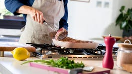 Person preparing grilled steak at home